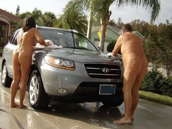 2 naked people washing a car
