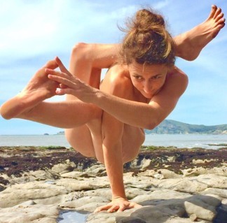 Nude woman in a complicated yoga post