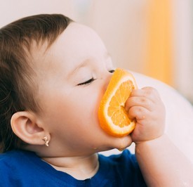 Child eating an orange.