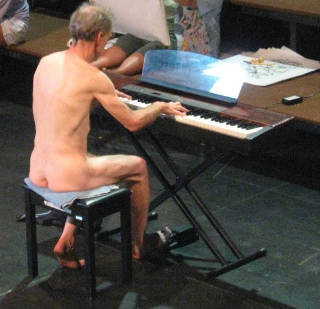 nude man playing piano